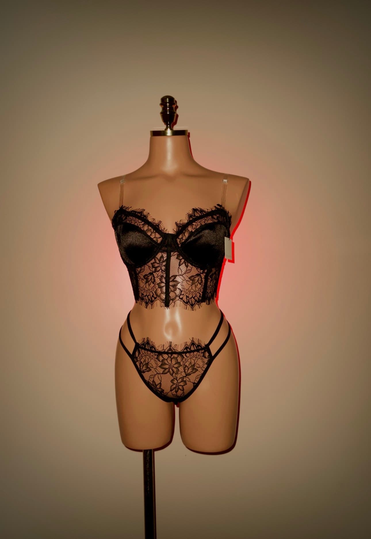 Conjunto preto de renda com bojo de cetim vestido em um busto de manequim